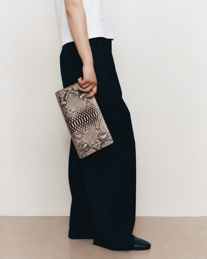 Woman carrying the Natural Taupe python clutch with minimalist clothing