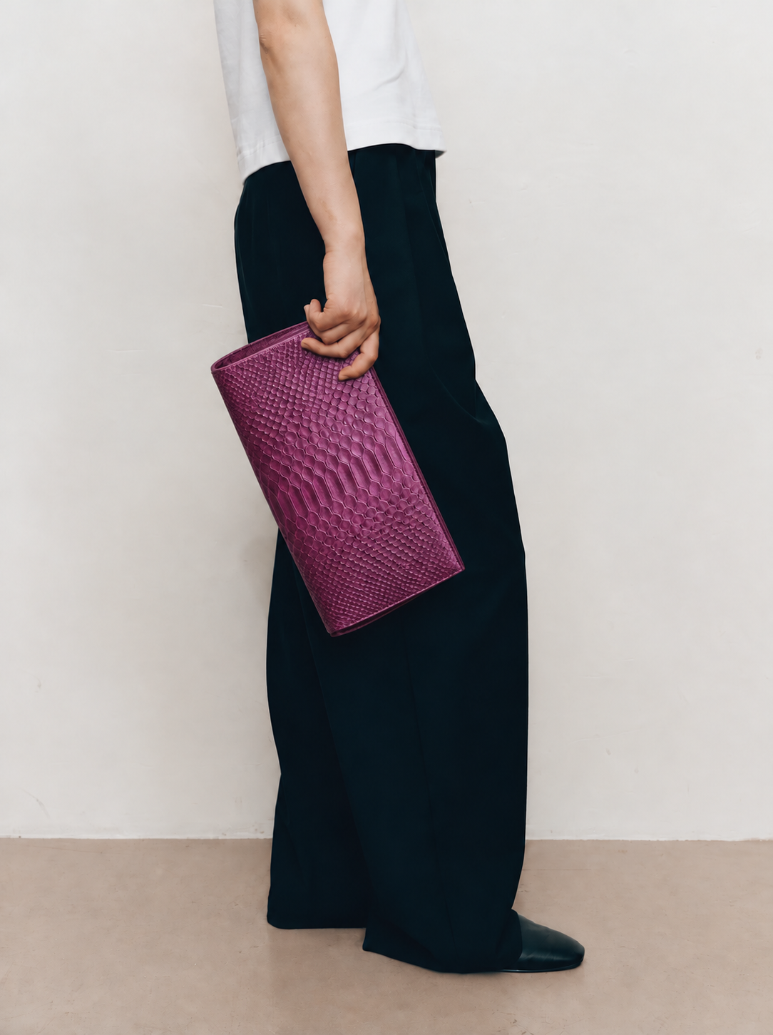 Smoky Plum python clutch carried at side