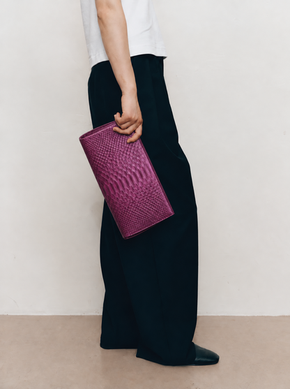 Smoky Plum python clutch carried at side