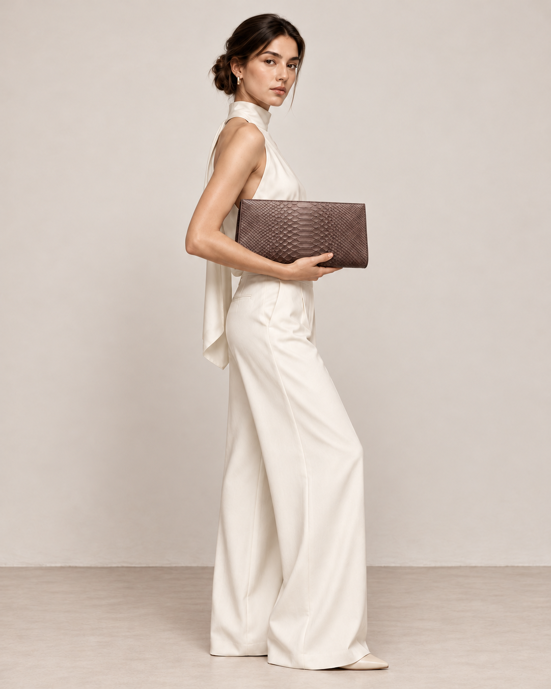 Woman wearing ivory and holding the Smoky Brown python clutch