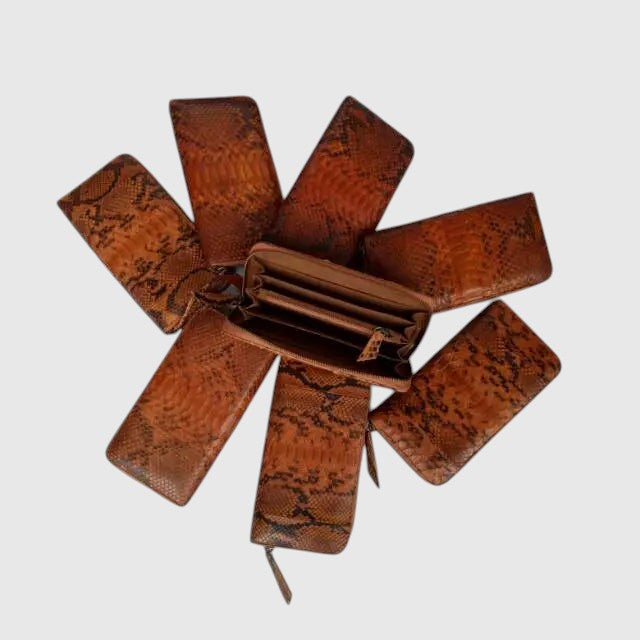 Portefeuille Leather craftman en cuir de serpent véritable marron, disposé en éventail avec un modèle ouvert.