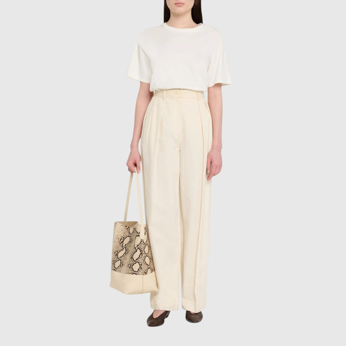 Sac cabas Savannah Python de Leather craftman en cuir beige et python porté par une femme en tenue décontractée