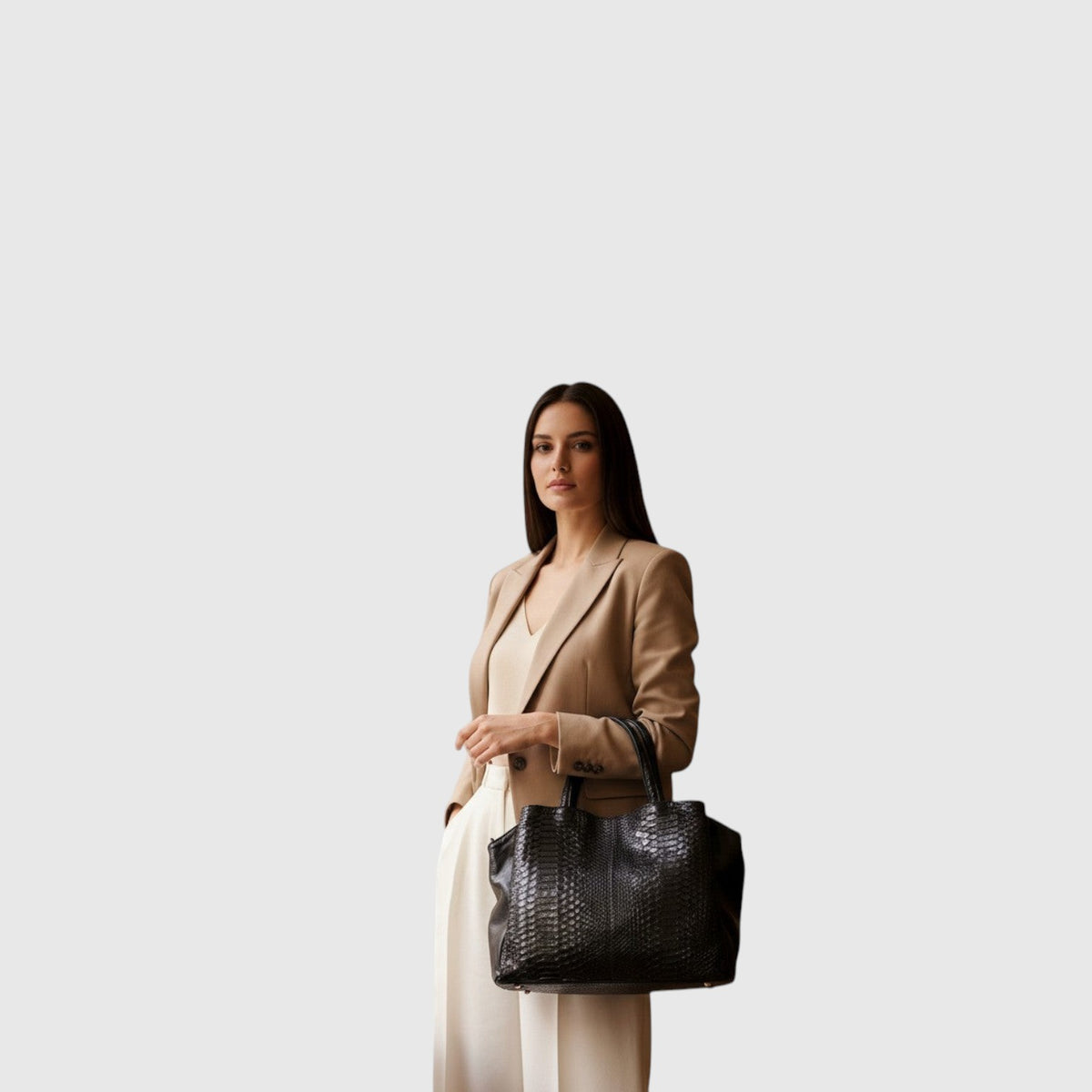 Femme portant un sac cabas Leather craftman en cuir de python noir texturé avec une tenue professionnelle beige