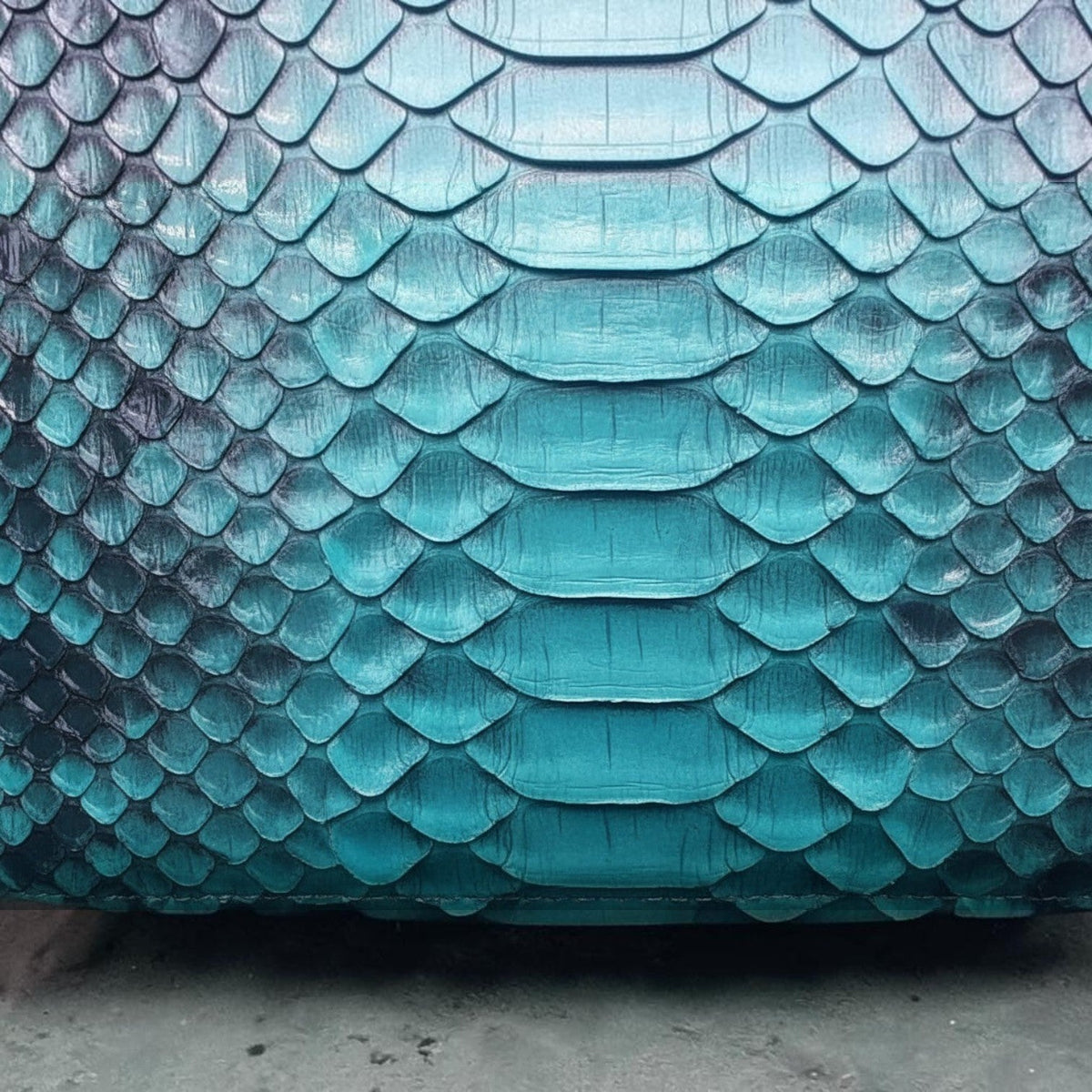 Gros plan sur la texture en cuir véritable gaufré python vert émeraude du sac Leather craftman
