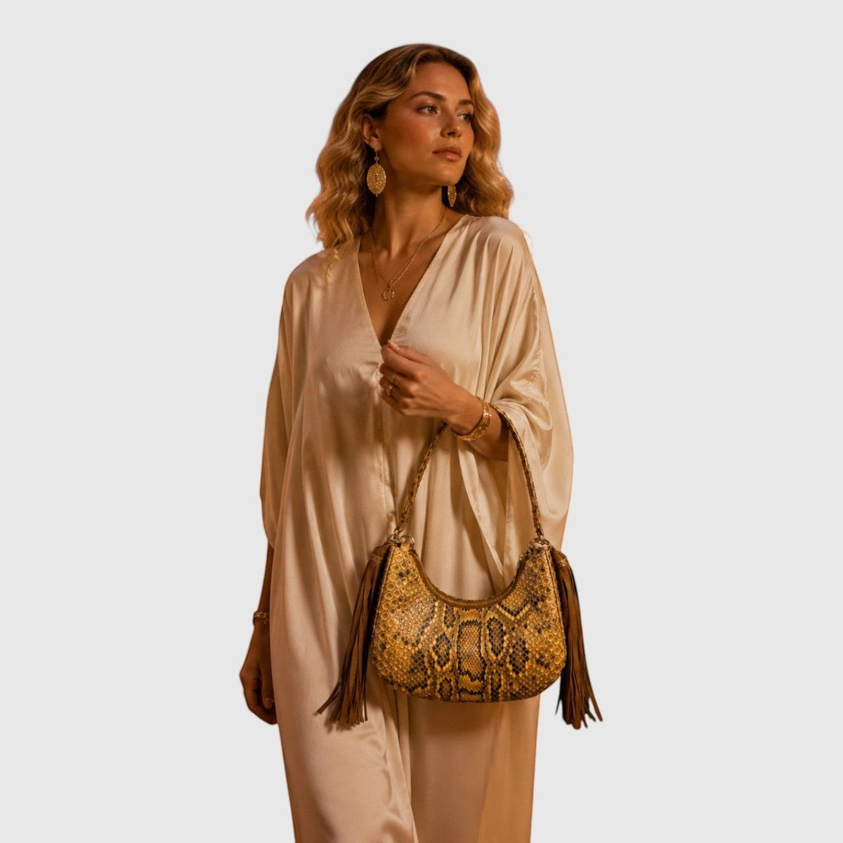 Femme portant le sac Fofana Sahara en cuir de serpent avec franges latérales, signé Leather craftman