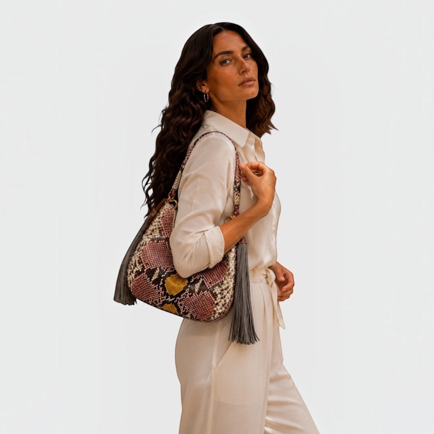 Femme portant le sac hobo Fofana Bag en cuir de python multicolore avec détails dorés et pompons par Leather craftman