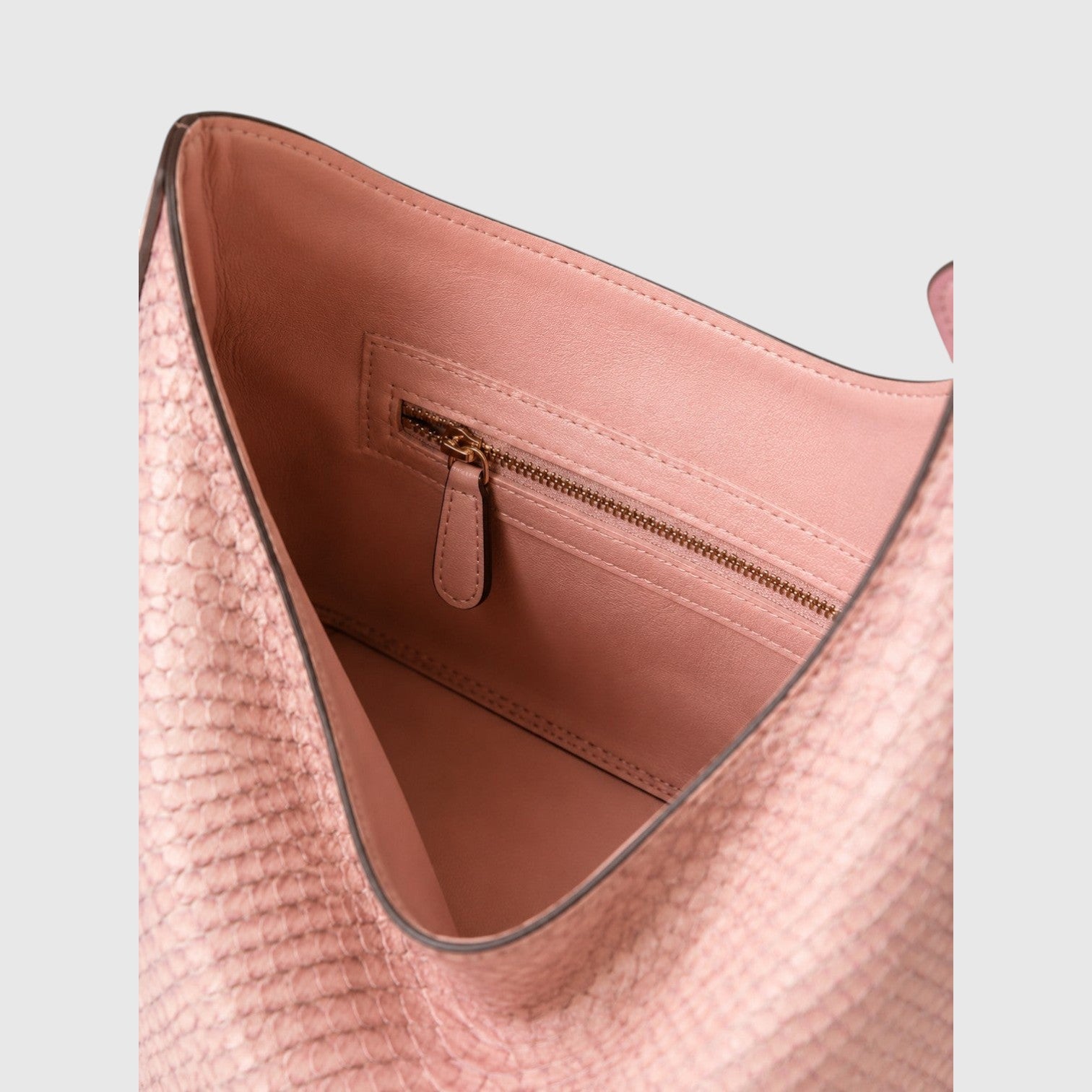 Intérieur doublé en cuir rose d'un sac hobo Leather craftman en python véritable avec poche zippée