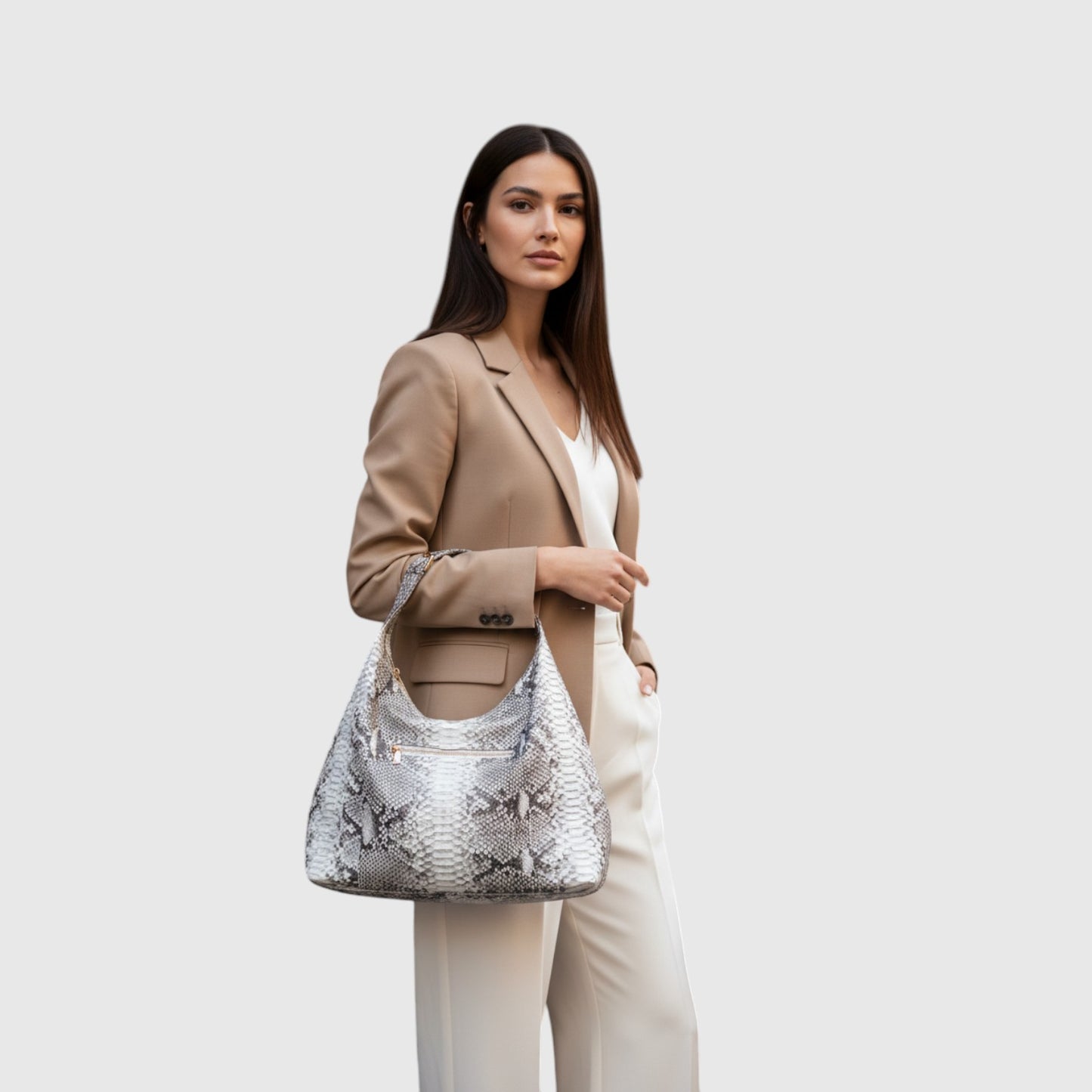 Femme portant un sac hobo en cuir à motif serpent gris et blanc de la marque Leather craftman avec un blazer beige