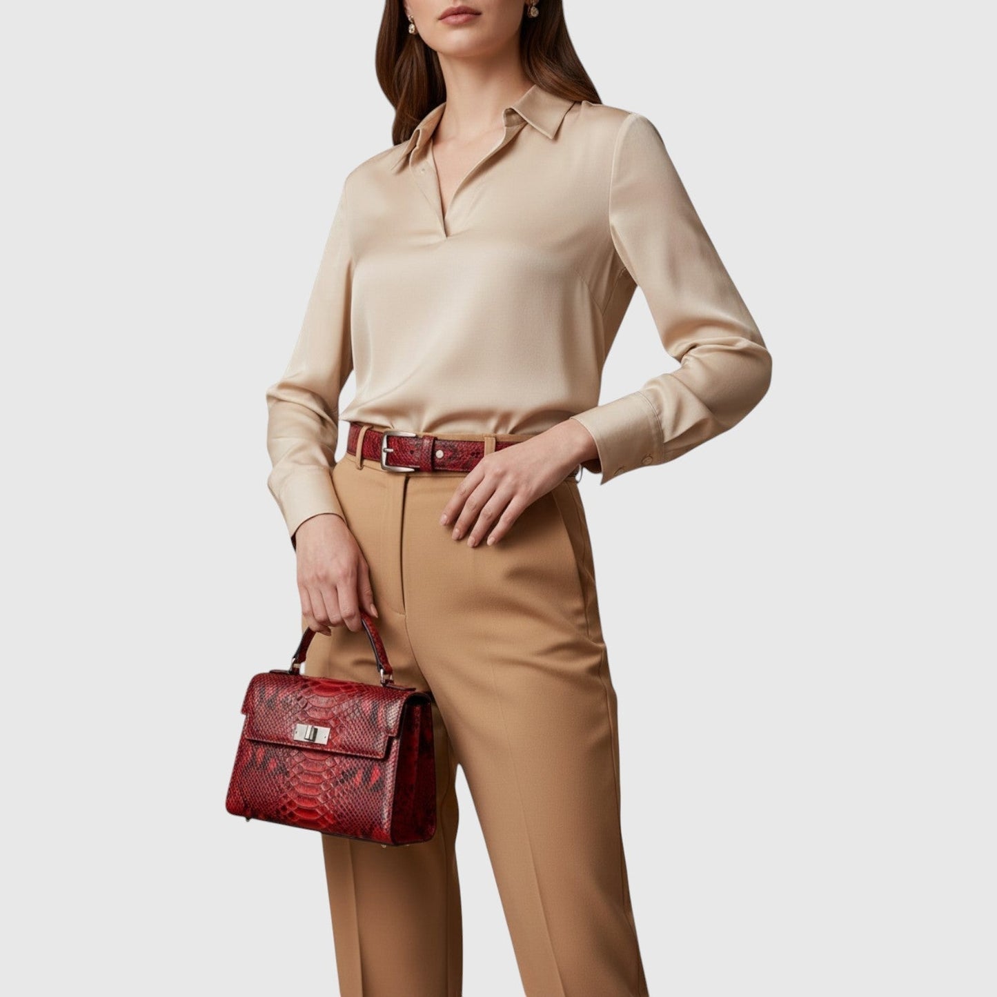 Femme portant un sac à main Leather craftman en cuir rouge rubis à motif python avec une tenue beige élégante