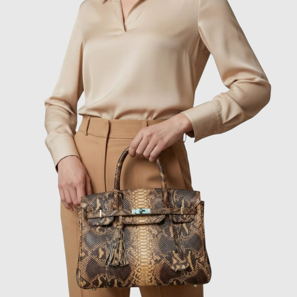 Sac à main Leather craftman en cuir de python véritable marron avec détails dorés porté à la main par une femme