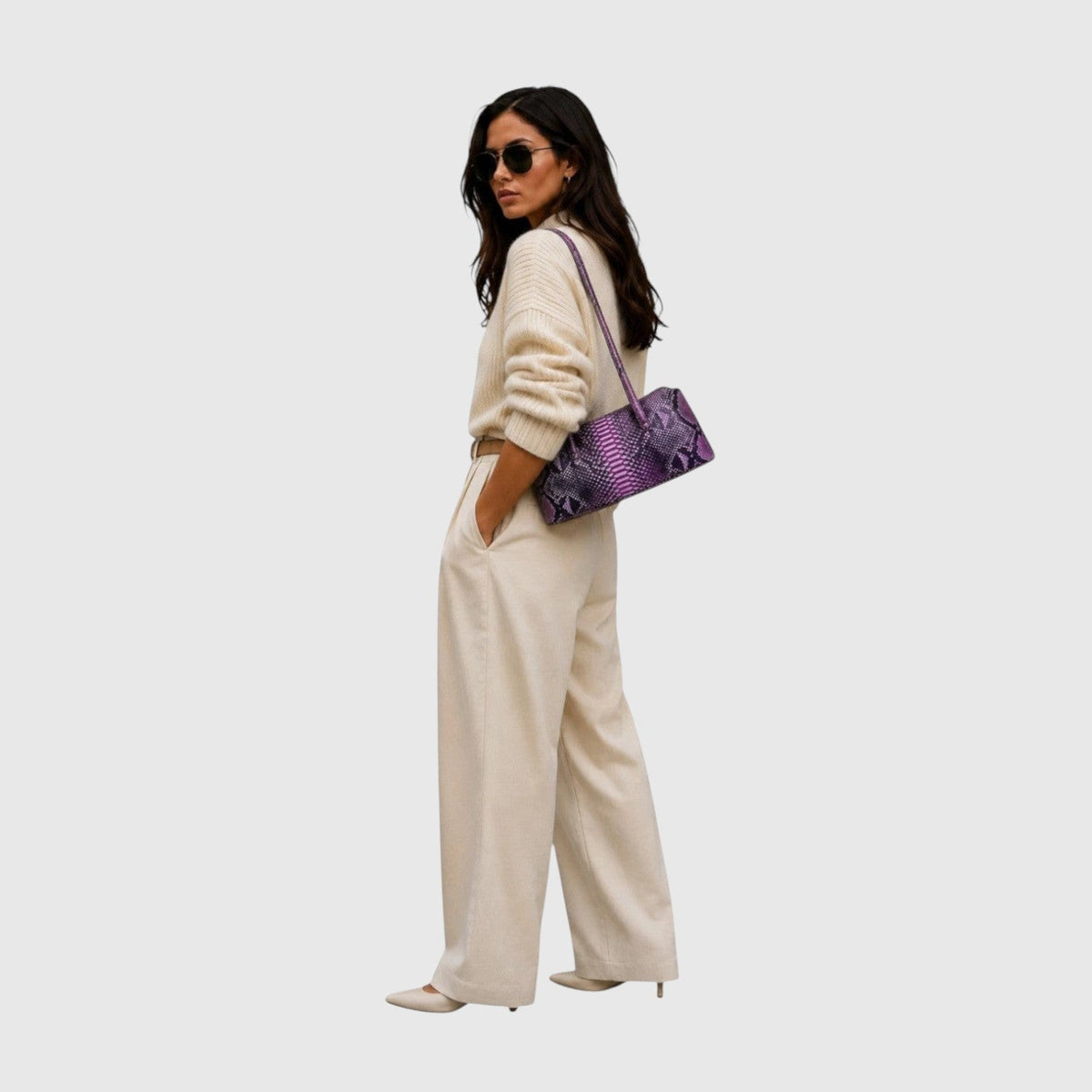 Femme portant un sac à main Leather craftman en cuir de python violet texturé avec une tenue beige élégante