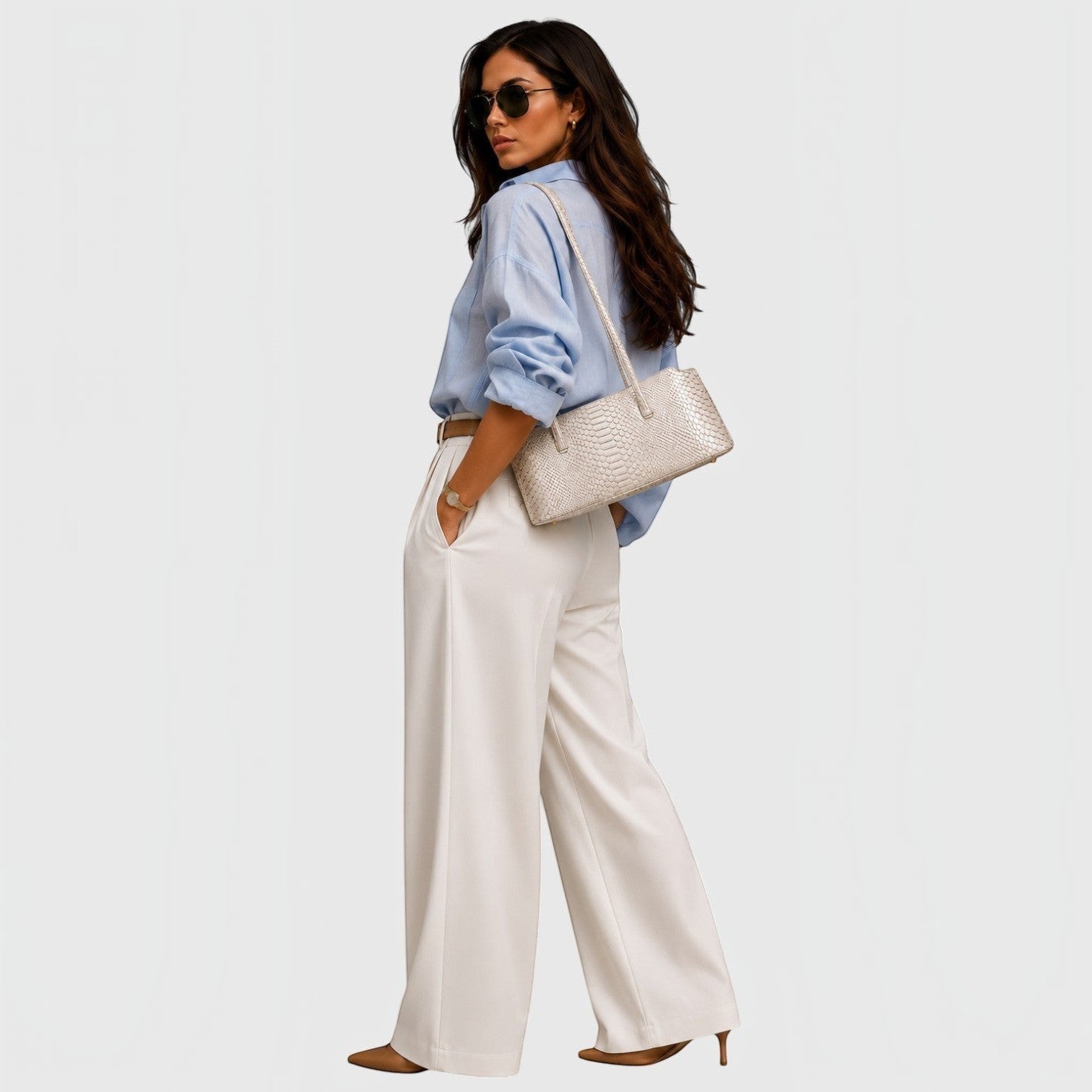 Femme portant un sac cabas Leather craftman en cuir de python ivoire avec une chemise bleue et un pantalon large