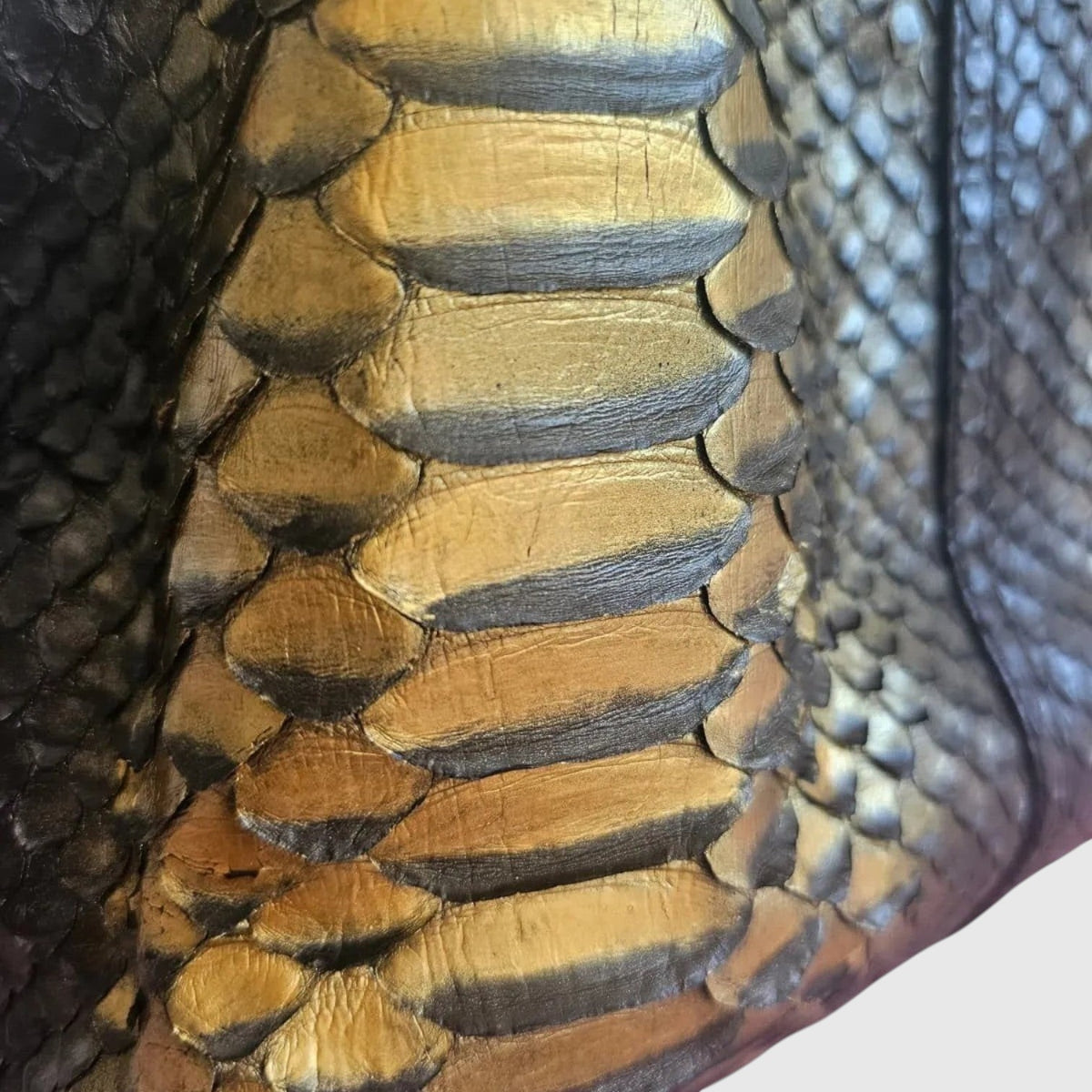 Gros plan sur le cuir de python noir et doré du sac à main Sahara Gold Python de la marque Leather craftman.
