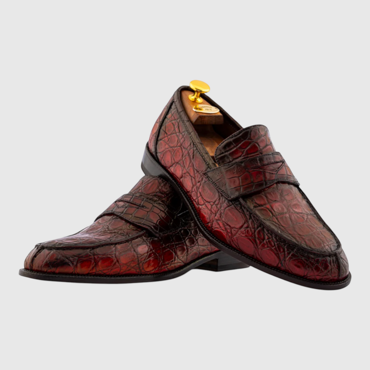 Close-up of hand-painted genuine crocodile leather on men's loafers in burgundy red