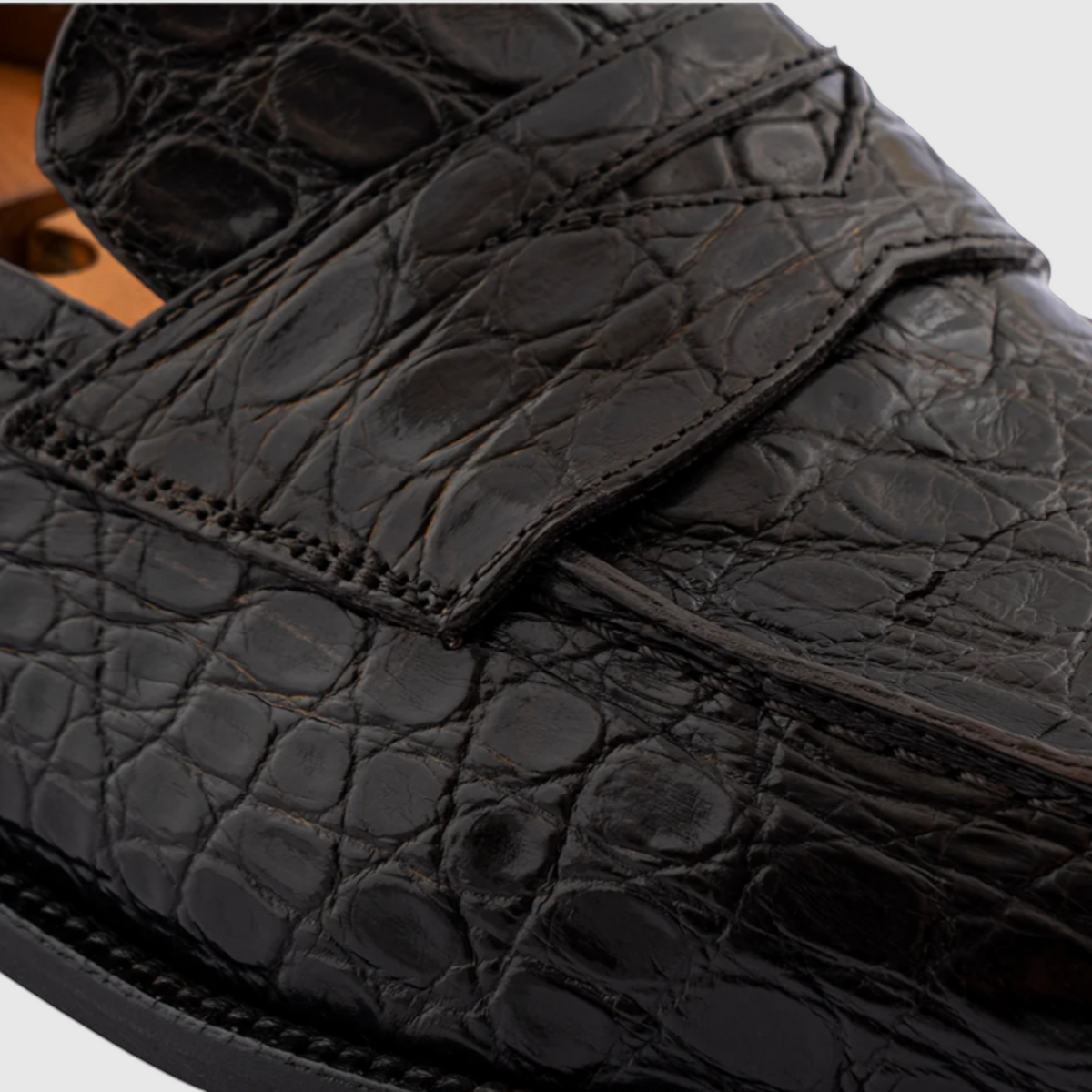 Close-up of hand-painted genuine crocodile leather on men's loafers in black