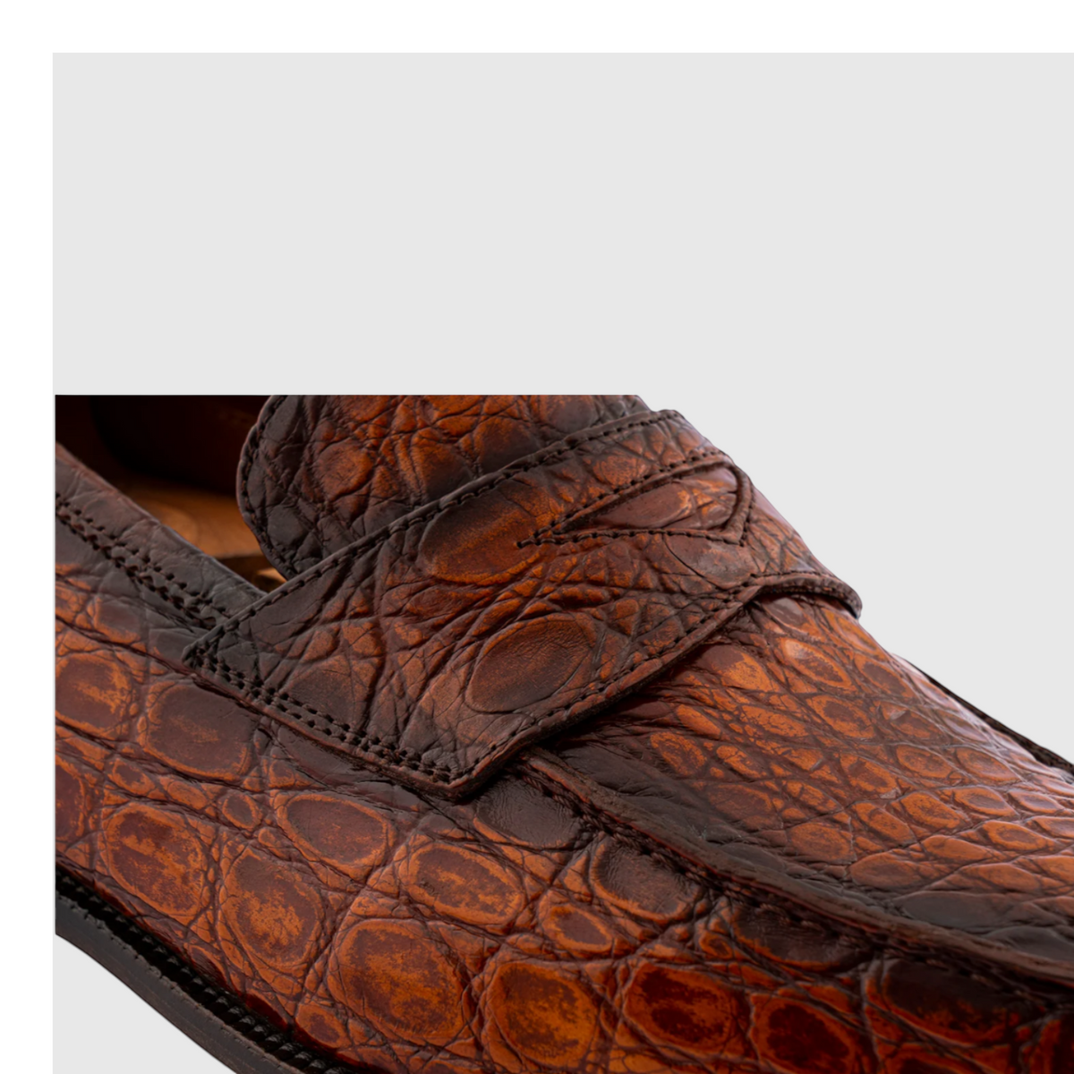Close-up of hand-painted genuine crocodile leather loafers in brown