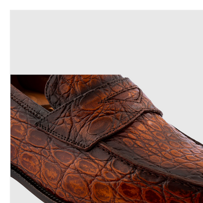 Close-up of hand-painted genuine crocodile leather loafers in brown